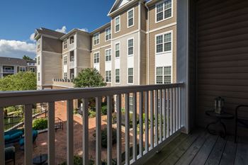 Apartment balcony with railing overlooking community courtyard