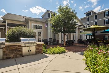 Outdoor grilling station with stone countertops and patio seating