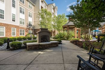 Outdoor fireplace with stone base and landscaping