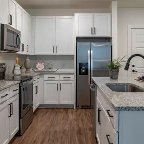 Ponte Vedra apartment for rent - A kitchen with white cabinets and a stainless steel refrigerator. at Atwater at Nocatee Apartments, Toledo, Florida