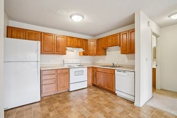 Vadnais Heights apartment for rent - A kitchen with white appliances and wooden cabinets.