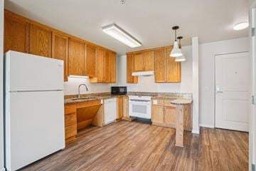 Newport apartment for rent - A kitchen with wooden cabinets and a white refrigerator.