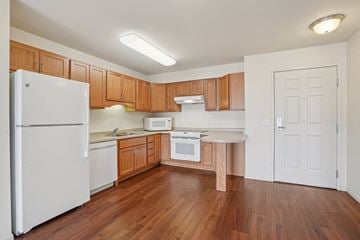 Forest Lake apartment for rent - A kitchen with wooden cabinets and a white refrigerator.