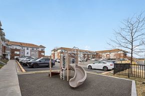 Shakopee apartment for rent - A playground with a slide and a car parked in the background.