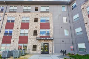 Burnsville apartment for rent - The Pillsbury Ridge building has a grey and red facade.