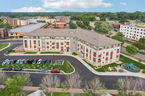 Burnsville apartment for rent - A large building with a parking lot in front of it.