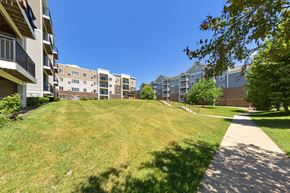 Rochester apartment for rent - A sunny day at a grassy area in front of apartment buildings.