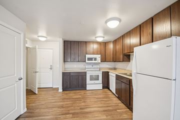 Savage apartment for rent - A kitchen with white appliances and wooden cabinets.