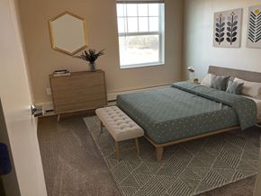 Rochester apartment for rent - a bedroom with a bed and a dresser and a window