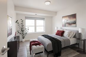 Burnsville apartment for rent - A bedroom with a large bed and a painting on the wall.