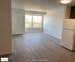 Rochester apartment for rent - A room with a white door and a window with a view of trees outside.