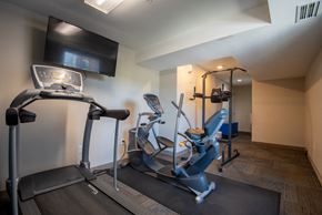Rochester apartment for rent - a gym with two treadmills and a tv in the corner