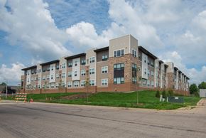 Rochester apartment for rent - A large apartment complex with multiple buildings and a parking lot in front.