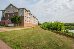 Waconia apartment for rent - Apartment building with a tree in front and a grassy area in front of it.