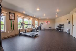 Mankato apartment for rent - A spacious room with a treadmill, exercise bike, and other workout equipment.