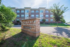 Mounds View apartment for rent - A sign for Boulevard Apartments stands in front of a building.