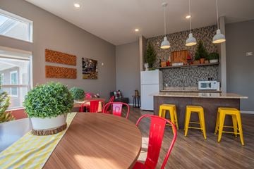 Mounds View apartment for rent - A kitchen with a wooden table and red chairs.