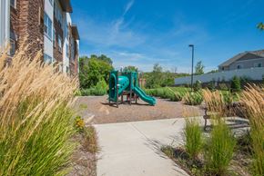 Vadnais Heights apartment for rent - A playground with a green slide in the middle of a grassy area.