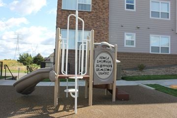 Shakopee apartment for rent - A playground with a slide and a sign with letters on it.