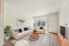 Bloomington apartment for rent - A living room with a white couch, a coffee table, and a television.