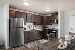 Bloomington apartment for rent - a kitchen and dining room with stainless steel appliances and dark wood cabinets