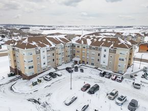 Rochester apartment for rent - Apartment complex with cars parked in the snow.