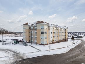 Rochester apartment for rent - A large apartment complex with a playground in the snow.
