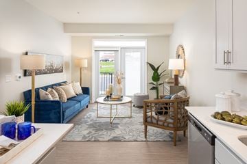 Burnsville apartment for rent - a living room with a blue couch and a white kitchen