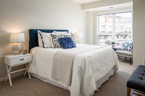 Burnsville apartment for rent - A bedroom with a large bed and a window overlooking a street.