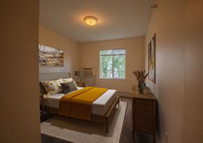 Rochester apartment for rent - a bedroom with a bed with a yellow blanket on it