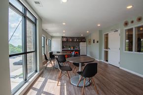 Rochester apartment for rent - a dining room with a table and chairs and a kitchen with a large window