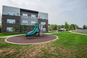 Waconia apartment for rent - a playground with a slide in front of an apartment building