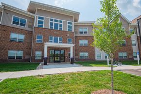 Mankato apartment for rent - A tree stands in front of a building with the number 875 on it.