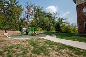 Savage apartment for rent - A playground with a green slide and a brown bench.