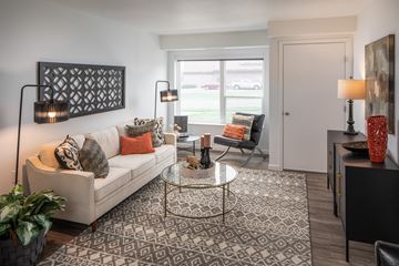 St. Paul apartment for rent - A living room with a couch, a glass table, and a painting on the wall.