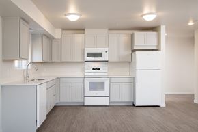 Burnsville apartment for rent - A white kitchen with a refrigerator, oven, and microwave.