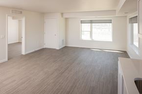 Burnsville apartment for rent - A spacious room with light wood flooring and white walls.