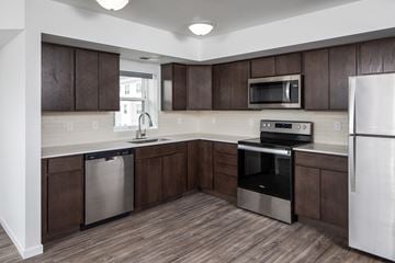 Newport apartment for rent - A kitchen with dark brown cabinets and stainless steel appliances.