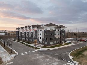 Newport apartment for rent - A large apartment complex with a parking lot in front.