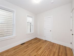 Cambridge apartment for rent - a bedroom with a door and two windows and a wood floor