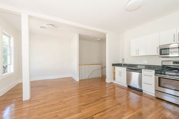 Cambridge apartment for rent - A kitchen with white cabinets and a wooden floor.