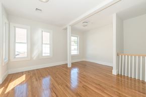 Cambridge apartment for rent - A room with wooden floors and white walls.