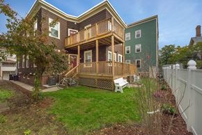 Cambridge apartment for rent - A house with a green wall and a wooden deck.