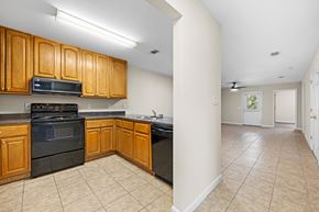 Lake Park apartment for rent - A kitchen with wooden cabinets and black appliances.