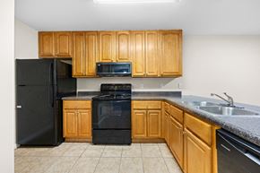 Lake Park apartment for rent - A kitchen with black appliances and wooden cabinets.