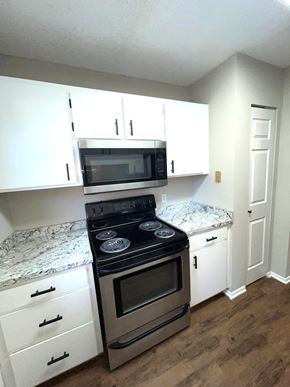 Valdosta apartment for rent - A kitchen with a stove top oven and microwave above it.