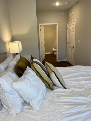 Simpsonville apartment for rent - a bedroom with a large bed with white sheets and pillows