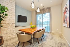 Spring apartment for rent - a dining room with a wooden table and chairs and a tv on the wall