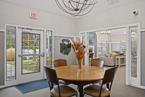 Stow apartment for rent - A dining room with a round table and chairs, a chandelier, and a view of the backyard through the glass doors.