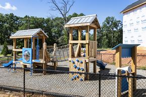 Asheville apartment for rent - A playground with a wooden swing set and a blue slide.